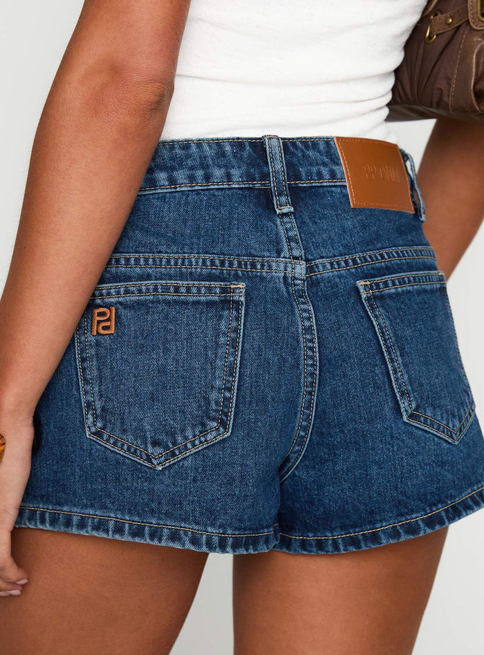 back view of model wearing Princess Polly Dreamful Low Rise Mini Denim Short Mid Wash Low Rise Shorts