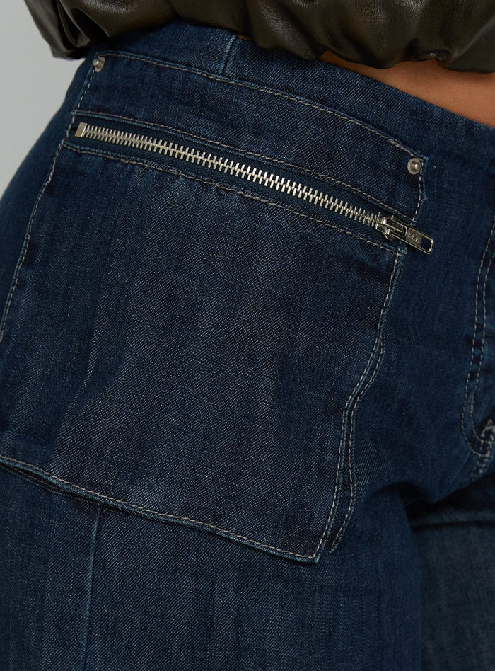 back view of model wearing Princess Polly Paltrow Mid Rise Wide Leg Cargo Jeans Dark Blue Wash Mid Rise Jeans