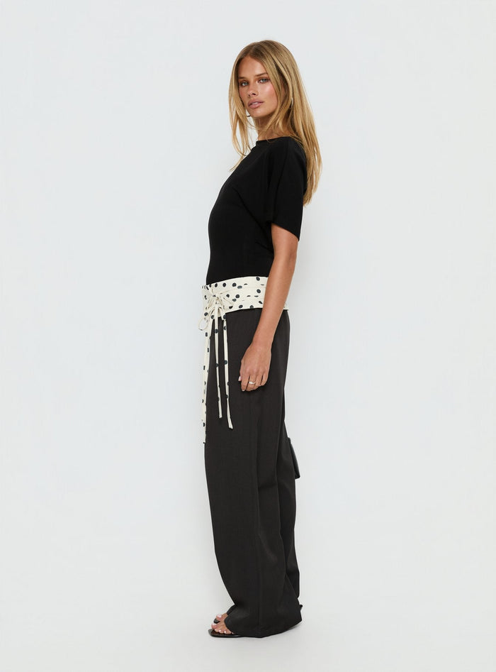 side view of model wearing Princess Polly Seneca Wrap Pants Charcoal Polka Dot Mid Rise Pants